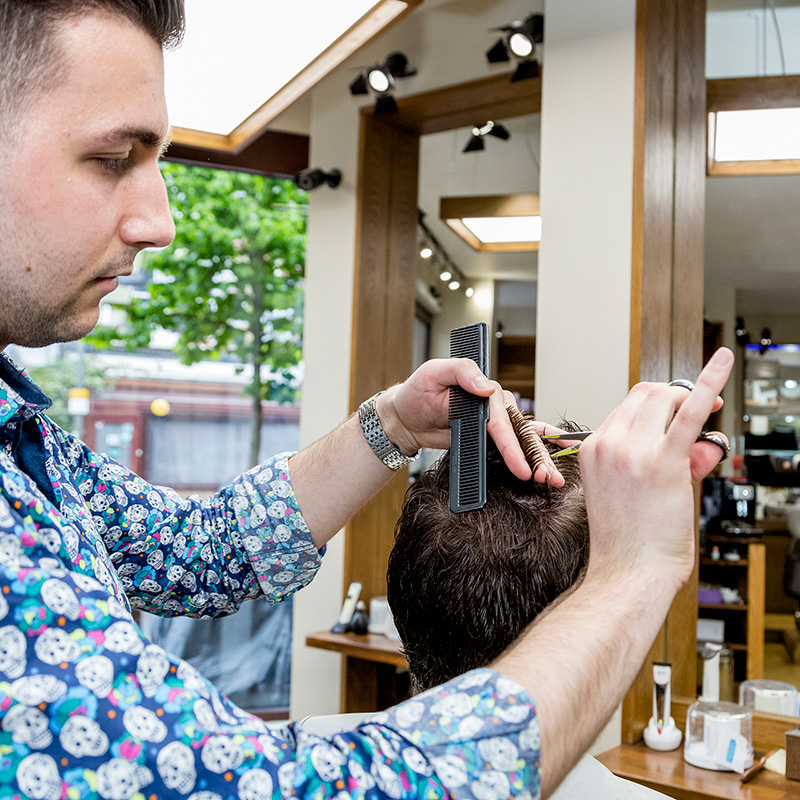 male barber cutting hair scissors comb